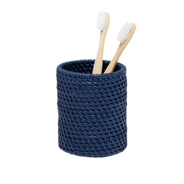 A dark blue textured cup from the Dalton Bath Collection by Pigeon & Poodle holds two bamboo toothbrushes with white bristles, set against a white background.