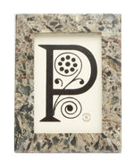 A decorative black letter "P" with circular and swirling designs, displayed in a Pigeon & Poodle Mixed Gray Marble Corsica Frame, 4 x 6.