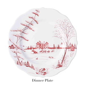 Juliska's Country Estate Winter Frolic Ruby Dinnerware Collection features a ceramic dinner plate decorated with festive winter scenes—an English estate, horse-drawn sleigh, ice skaters, trees, and distant buildings.