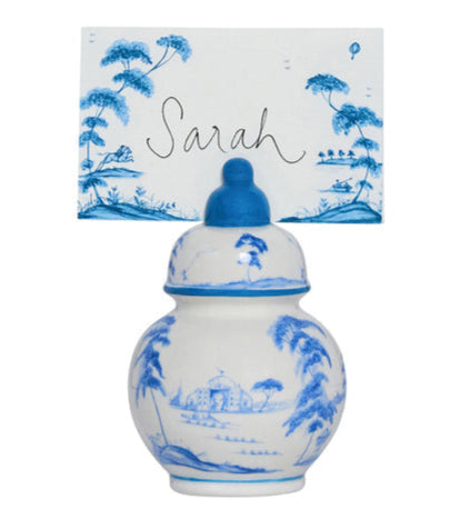 The Juliska Country Estate Place Card Holder Set features a Delft Blue porcelain jar with a landscape design, elegantly holding a place card labeled "Sarah" in calligraphy.