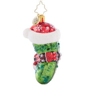 The Christopher Radko Chilly Christmas Pickle Gem Ornament features a green pickle in a red Santa hat, a red-and-white scarf, and a gold star hanger—perfect for your festive pickle-hunt tradition.