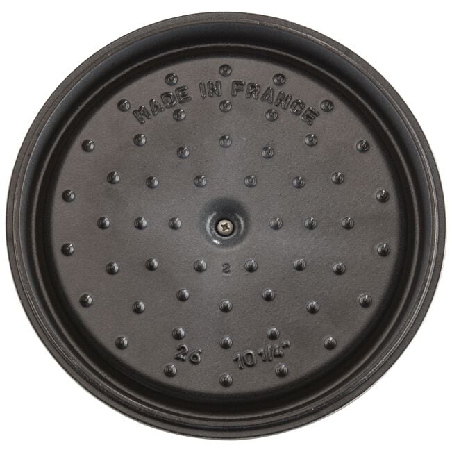 Round black cast iron lid from the Staub Cast Iron Dutch Oven Collection, featuring raised bumps and “MADE IN FRANCE” and “26 10 1/4” embossed—ideal for slow-cooking recipes.