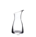 The Simon Pearce Barre Carafe Collection features a handmade glass carafe with a narrow base, wide middle, and slanted opening. Shown upright on a white background with "Small" labeled below.
