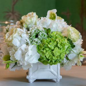 The Hive Floral Studio Live Classic Floral Arrangement features white and green sympathy flowers in a small, elegant ceramic vase, perfect for display on a table.