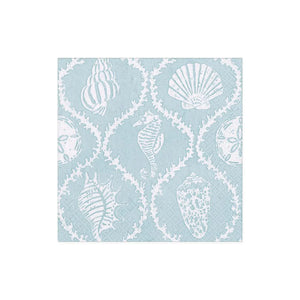 The Seychelles Aqua Collection napkin by Caspari features a light blue square triple-ply design with white outlines of seashells, sand dollars, and a seahorse in a repeating pattern.