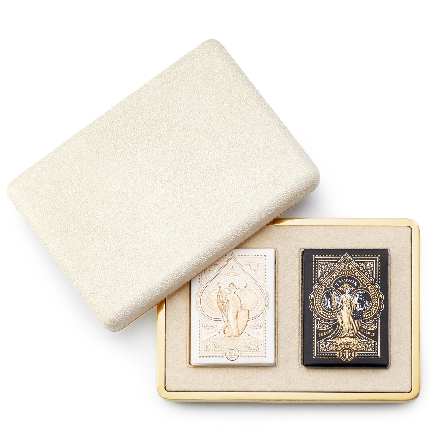 The Aerin Shagreen Card Set in Cream features two intricately designed playing card decks, one white and one black, presented in a cream-colored textured case with an embossed shagreen finish and a partially open lid.
