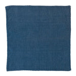 The Juliska Berry Trim Napkin Collection features a square, dark blue woven cotton napkin with a finely textured surface and delicate pom-pom trim, shown on a white background.