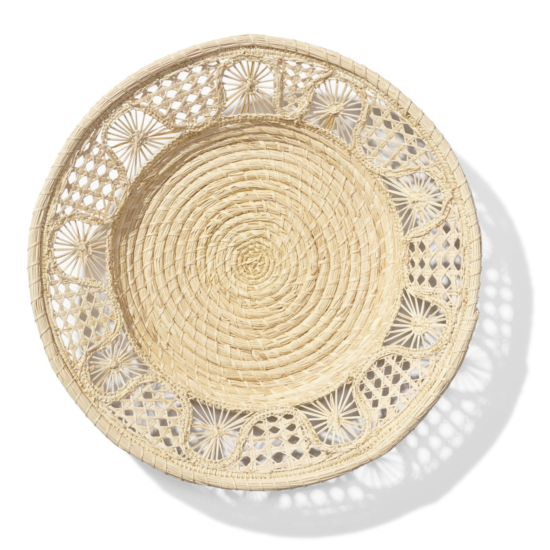 The Aerin Large Raffia Basket, handwoven by Colombian artisans, showcases an intricate open-lace rim and is pictured against a white background.