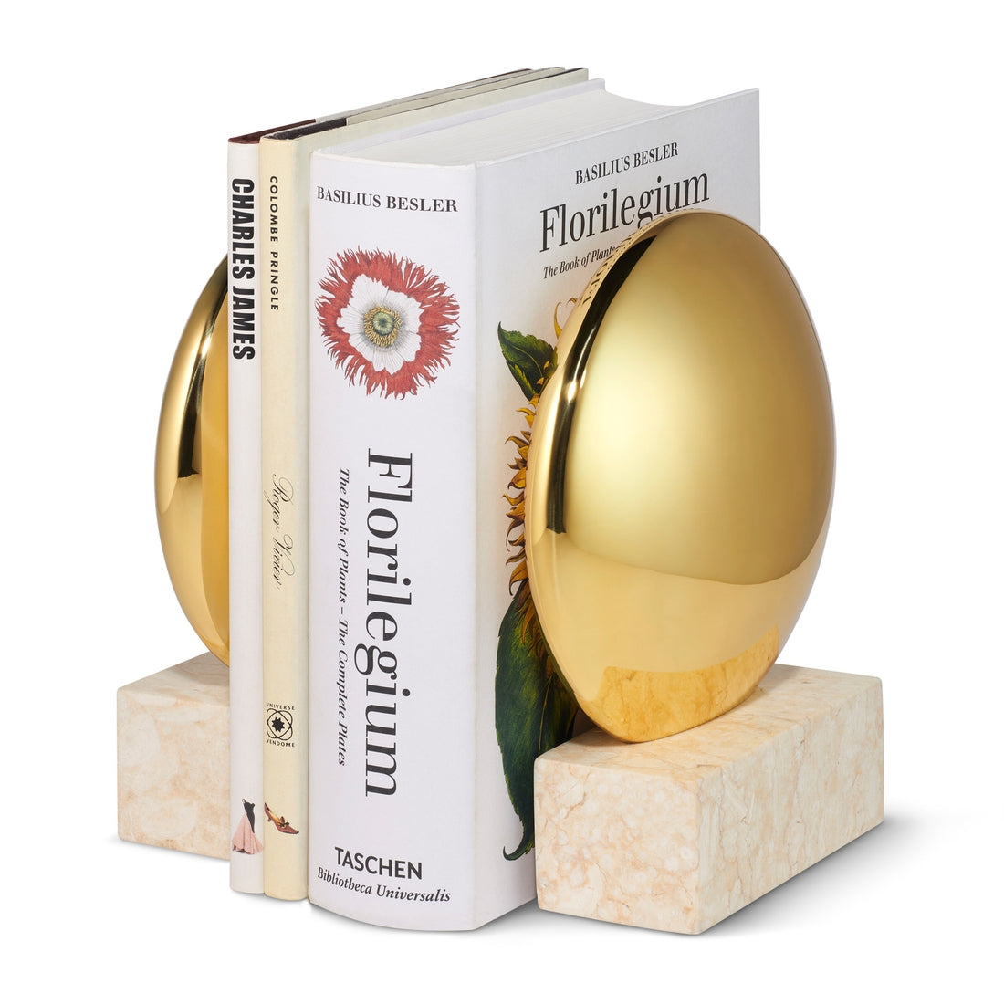 Three books stand upright between two Aerin Constantin bookends, each featuring a brass finish and cream marble base for a Mid-century feel. The display includes "Florilegium" and "Charles James.