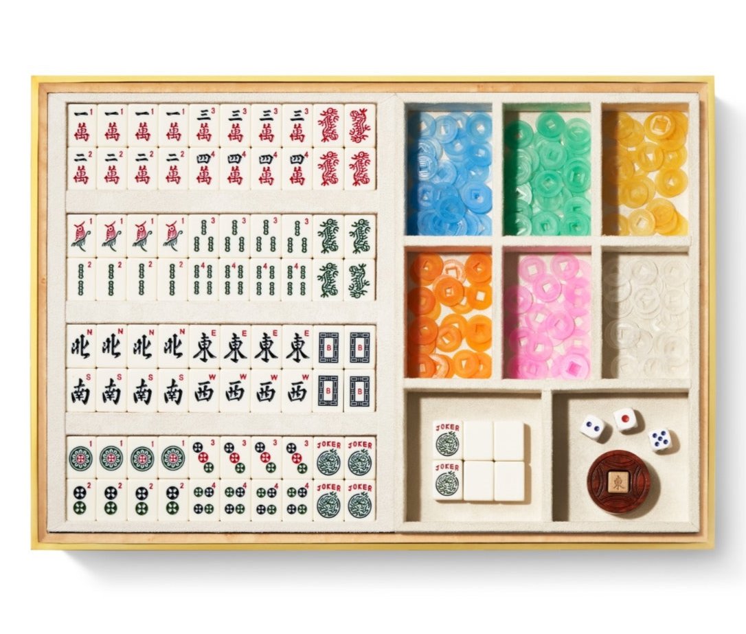 The Aerin Luxe Shagreen Mahjong Set in Cream features vibrantly engraved tiles, colorful chips, dice, and accessories, all neatly organized in a luxurious cream shagreen box.