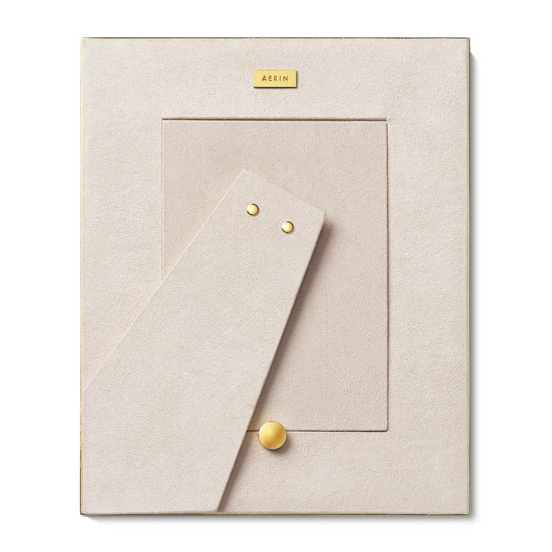 The Colette Cane Frame by AERIN is a beige rectangular picture frame with a cane-textured surface, gold accents, and "AERIN" on a gold plate at the top. The stand is extended.