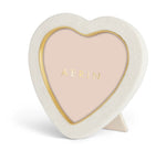 The Cream Shagreen Heart Frame by Aerin features a white textured border, brass detailing on the gold inner rim, and "Aerin" in gold on the beige placeholder.