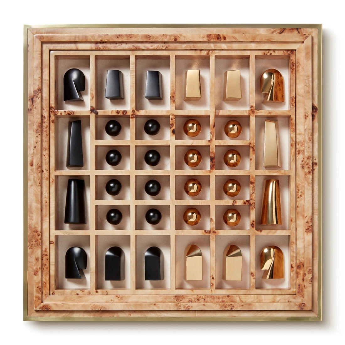The Colette Cane Chess Set by Aerin features abstract black and gold-plated pieces arranged in a wooden grid-style box, shown from above.