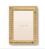 Rectangular gold Loretta Frame from Aerin with a twist design and cream-colored insert labeled "AERIN"—an elegant way to display photos.