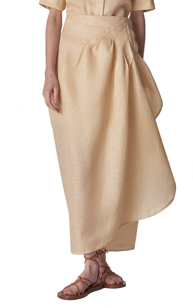 A woman in a beige CO Wrap Skirt and white shirt made from a viscose blend crepe.