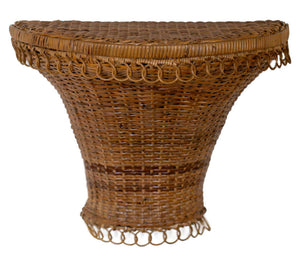 The Anna Bracket by Varnish Collection features a woven wicker design with a wide, flat top, flared sides, and decorative looped edges, adding vintage charm to any space.