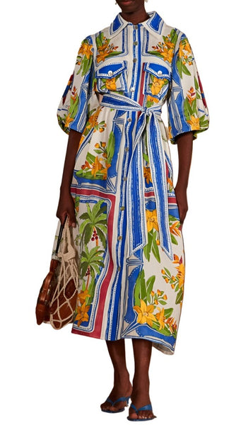 Woman wearing a Farm Rio Off-White Tropical Destination Midi Dress with a belt, holding a net bag, standing against a white background.