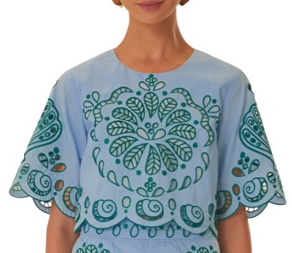 Woman wearing a Farm Rio Light Blue and Green Graphic Richelieu Crop Top, cropped to show only her torso and neckline.