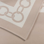 A close-up of the Frette Beige/Milk Chains Throw, crafted in Italy from luxurious virgin wool and featuring an elegant chain link border pattern.