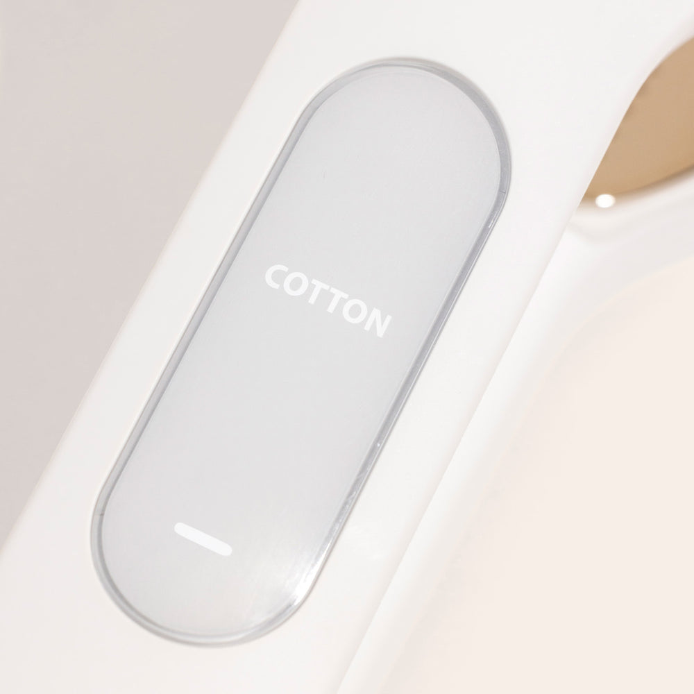 Close-up of Nori Inc's Nori Press Steam Iron's minimalistic white control panel labeled "Cotton," ideal for compact travel use.
