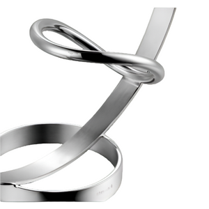 Two intertwined polished metal loops reflect light, embodying the sophisticated design of the Christofle Vertigo Wine Server—a silver-plated oenophile’s statement piece inspired by Andrée Putman. Pictured on a white background.