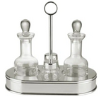 The St. James 5 Piece Oval Cruet Set includes two crystal containers with stoppers, displayed on a silver-plated tray stand with a central handle for elegant separation.