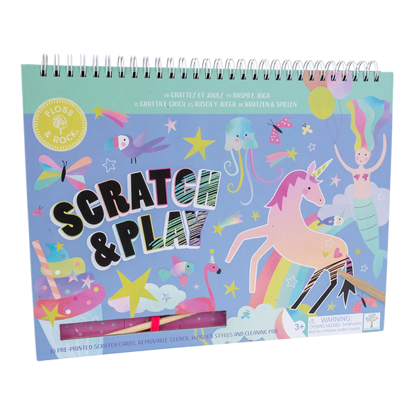 A spiral-bound Floss and Rock Fantasy Scratch & Play activity book features illustrations of unicorns, stars, and other whimsical elements on its cover, suggesting creative fun and interactive content for children aged 3 and above.