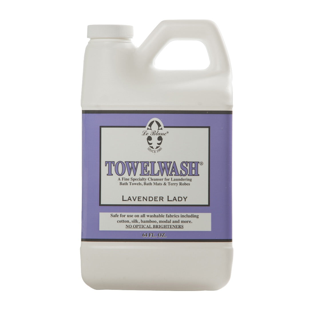 A plastic bottle of Le Blanc Towel Wash laundry detergent with a purple label and black text, designed for absorbent towels, robes, and other washable organic fabrics.