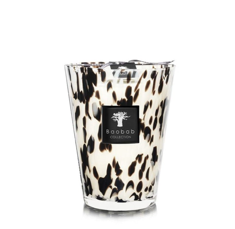 A Baobab Pearls Black Candle from the Baobab Collection in a hand-blown glass holder with a black and white animal print design.