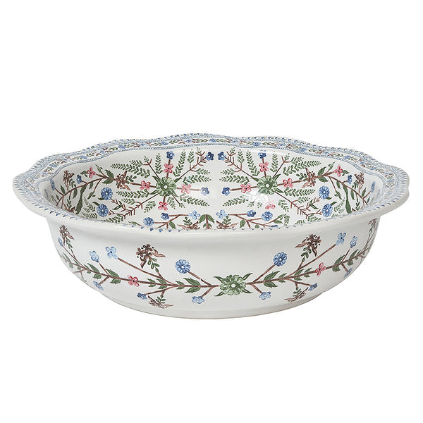 The Juliska Villa Seville Chambray Dinnerware Collection features a round ceramic bowl with scalloped rims and a floral pattern in green, blue, pink, and brown on white—ideal for enhancing your floral table setting.