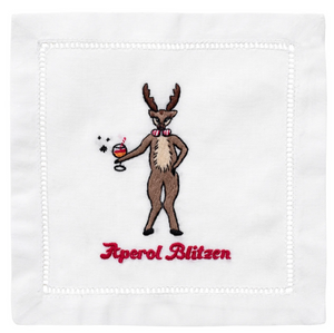 The Aperol Blitzen Cocktail Napkins by August Morgan feature an embroidered reindeer with a red-and-white bow tie holding an Aperol Spritz, plus "Aperol Blitzen" text underneath.