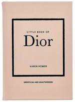 The cover of the "Little Book of Dior" by Graphic Image, showcasing a minimalist design with a blush pink background and black text, captures the essence of Parisian haute couture and honors Christian Dior's iconic new look silhouette.