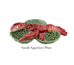 This Bordallo Pinheiro ceramic appetizer plate showcases a red lobster on a vivid green leaf backdrop, embodying the spirit of the Cabbage with Lobsters Serveware Collection.