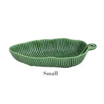 From the Bordallo Pinheiro Banana Leaves Salad Bowl Collection by Bordallo Pinheiro, this small green leaf-shaped ceramic bowl is perfect for serving salads against a crisp white background.