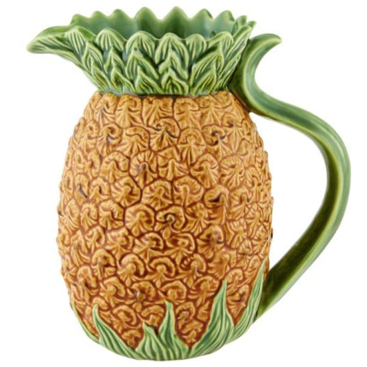 The Hive Pineapple Pitcher is a ceramic pitcher shaped and textured like a pineapple, featuring green leaves that form the top and handle.