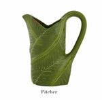 The Bordallo Pinheiro Bananas From Madeira Serveware Collection features a green ceramic pitcher with a handle, shaped like a tropical leaf, shown against a plain white background with "Pitcher" labeled below.