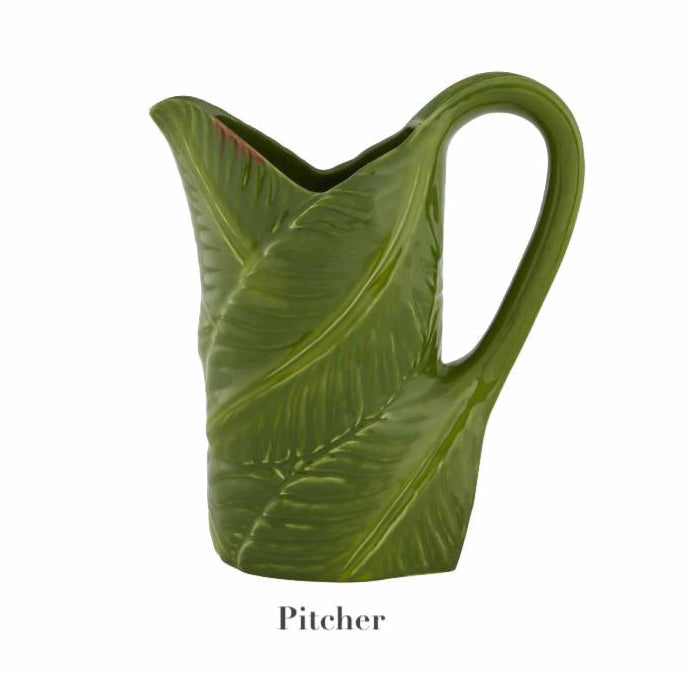 The Bordallo Pinheiro Bananas From Madeira collection features a green ceramic pitcher with a leaf pattern on a white background, capturing the charm of handmade artistry. Part of our serveware collection, it includes the label "Pitcher.