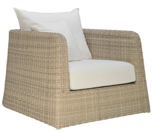 The Zeya Outdoor Lounge Chair by Janus et Cie is a weather-resistant wicker armchair with a boxy shape, white seat and back cushions, and two white throw pillows—ideal for stylish outdoor living.