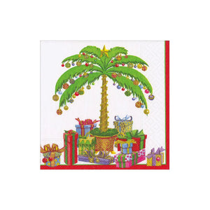 The Caspari Deck the Palm Cocktail Napkin features a festive palm tree with ornaments, surrounded by presents, all set against a white background with a red border.