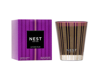 The Nest Autumn Plum Candle Collection features a premium scented candle and a purple patterned box with gold and black accents, perfect for bringing fall elegance into your home.