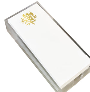 The Coral Skinny Notepad by Black Ink features a white rectangular design with a gold foil coral motif, elegantly presented in a clear Lucite holder.