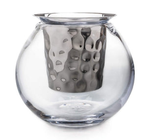 The Simon Pearce Hampton Chiller is a clear, round glass teacup crafted with handmade glassblowing techniques and features a metallic, hammered-texture infuser inside.