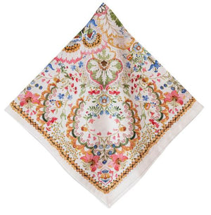 The Sofia Napkin Set by Juliska features square, white cotton napkins adorned with a vibrant floral and paisley pattern in green, blue, gold, pink, and orange for a fantasy garden-inspired touch.