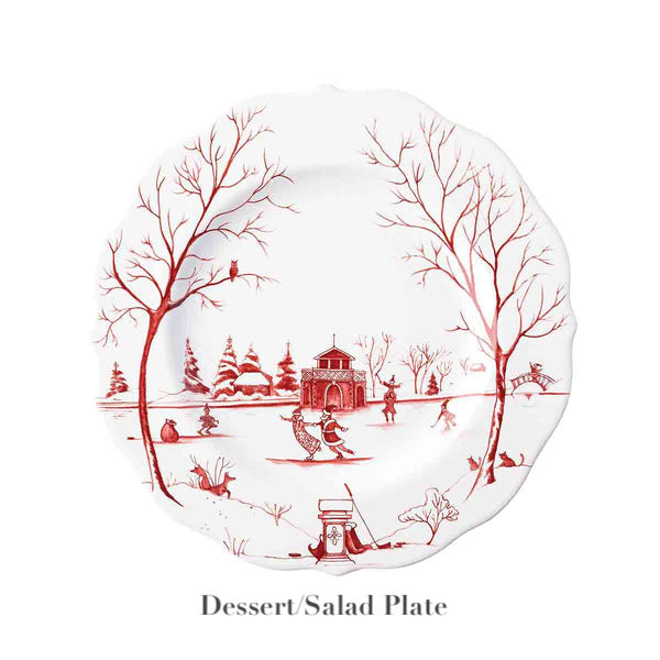 The Juliska Country Estate Winter Frolic Ruby Dinnerware Collection features a white ceramic dessert/salad plate adorned with a festive winter scene—trees, people, gazebo, and snow—below which is labeled "Dessert/Salad Plate.
