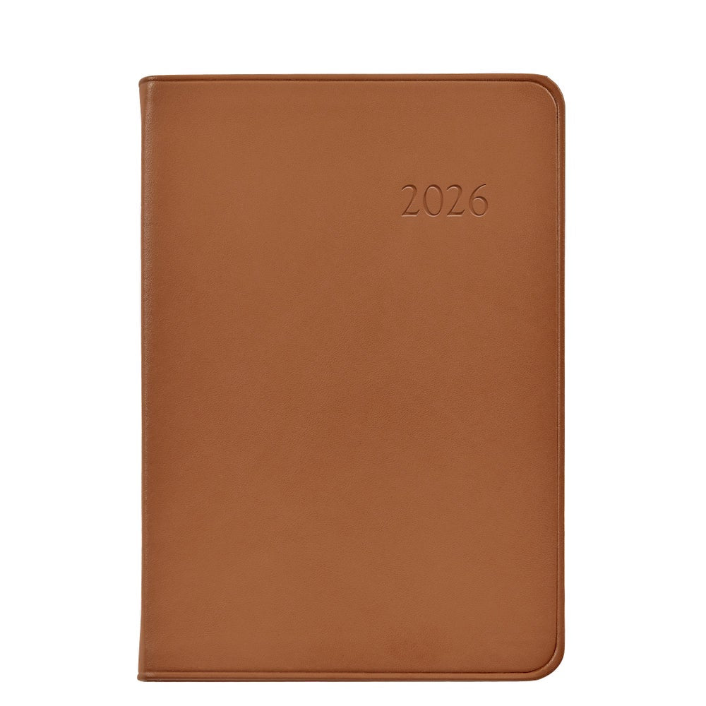 The Graphic Image 2026 Daily Journal Planner Collection features a brown leather-bound diary with "2026" embossed on the cover, designed for day-at-a-view scheduling and organized planning.