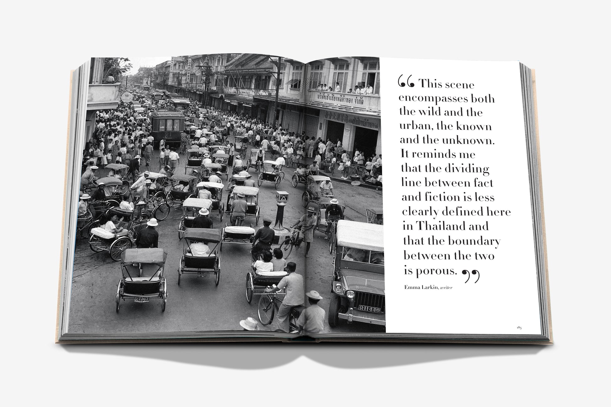 An open book, "Bangkok Spirit" by Assouline, displays a black and white photo of a bustling Bangkok street scene with rickshaws, pedestrians, and vibrant street food stalls. The right page features a quote.