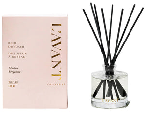 The L'Avant Collective Blushed Bergamot Reed Diffuser in a clear glass bottle with black reeds and its pink box fills your space with orange blossom and warm amber notes.