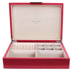 From the Addison Ross Shagreen Jewelry Box Collection, this red box has a beige suede interior with ring sections, small compartments, a larger space, and a silver clasp. The lid is lined with "Addison Ross London.