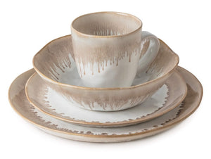 The Burlington Bluff Dinnerware Collection by Simon Pearce is a four-piece ceramic set—plate, salad plate, cereal bowl, and mug—with beige and white Bluff glaze inspired by classic pinch-pot style.
