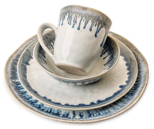 The Simon Pearce Burlington Pool Dinnerware Collection includes a cup, bowl, salad plate, and dinner plate with blue and gray organic drip design on white, inspired by Burlington pottery.